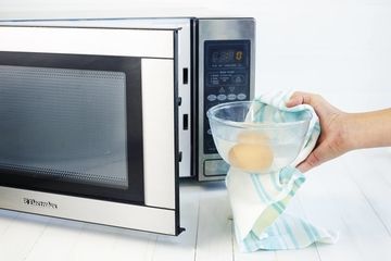 Eggs being placed in a microwave